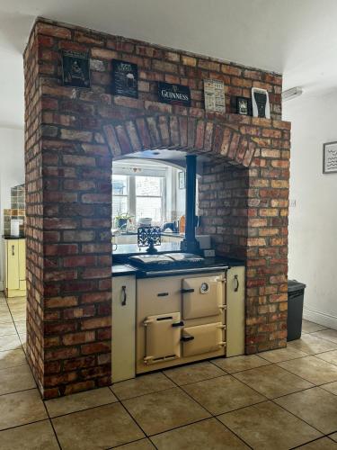 a kitchen with a brick wall and an oven at The Victorian Townhouse Portrush in Portrush