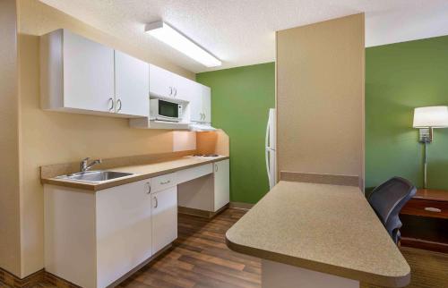 a small kitchen with white cabinets and a sink at Extended Stay America Suites - Washington DC Germantown Milestone in Germantown