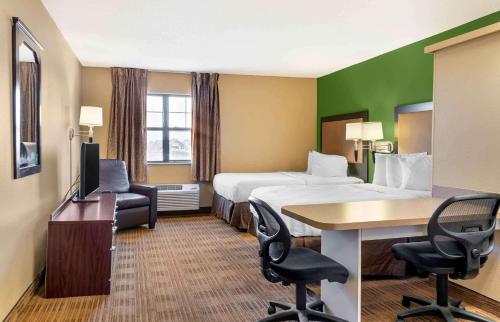 a hotel room with two beds and a desk and chairs at Extended Stay America Suites - Washington DC Germantown Milestone in Germantown
