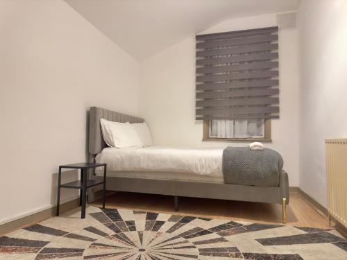 um quarto com uma cama e uma janela em Entire 3 Bedroom Home With Garden In London em Edmonton