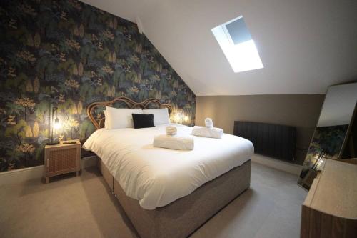 Un dormitorio con una cama grande con toallas. en Pass the Keys Apartment 4 Old Conservative Club in Historic Town, en Caernarfon