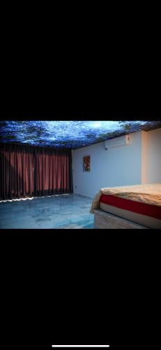 Zimmer mit einem Bett und einem Fenster mit Vorhängen in der Unterkunft Sunset view in Cheraga