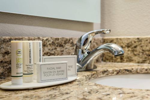 a bathroom sink with a toothbrush and a tube of sunscreen at TownePlace Suites by Marriott Minneapolis near Mall of America in Bloomington