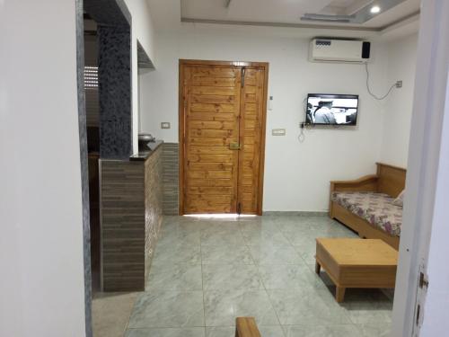 Cette chambre dispose d'une porte, d'un lit et d'une télévision. dans l'établissement Dar allouch, à Hennchir Ksar Rhaleb
