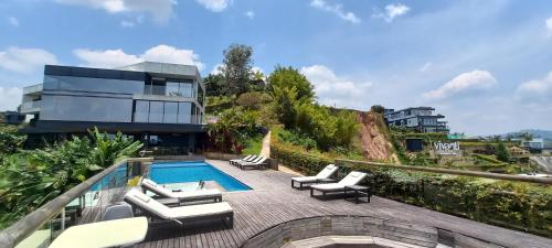 a swimming pool with lounge chairs and a building at MURAT HOTEL in Guatapé