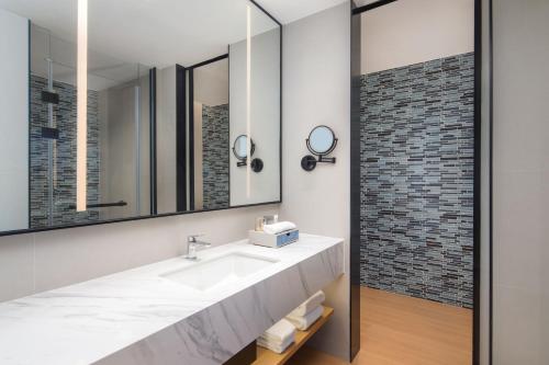 W łazience znajduje się umywalka i lustro. w obiekcie Fairfield by Marriott Chengdu Hi-Tech Zone w mieście Chengdu