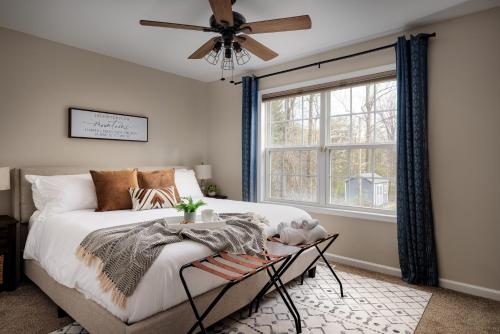 a bedroom with a bed with a fan and a window at The Mountain View Cottage - Deck and Firepit 6 Mins To River! Perfect For Families in Harpers Ferry