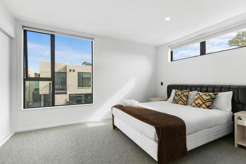 a bedroom with a bed and a large window at Brand new 3 Bed 3 Bath in Christchurch