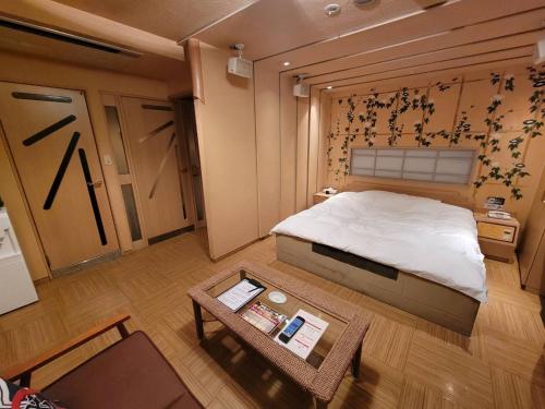 una piccola camera con letto e tavolo di TsukinoAkari月燈 姫路城隣 a Himeji