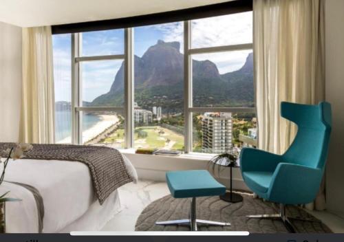 - une chambre avec une grande fenêtre et 2 chaises bleues dans l'établissement Hotel nacional, à Rio de Janeiro