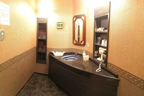 a bathroom with a sink and a mirror at TsukinoAkari月燈 姫路城隣 in Himeji