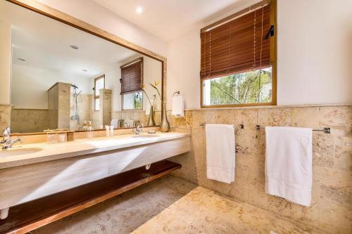 a bathroom with a large sink and a large mirror at Marina Pointe Apartments in La Romana