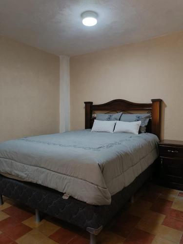 ein Schlafzimmer mit einem großen Bett in einem Zimmer in der Unterkunft El Rinconcito de la Antigua in Antigua Guatemala