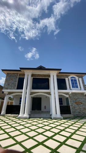 a house with pillars on the front of it at Century Premier Suite in Accra