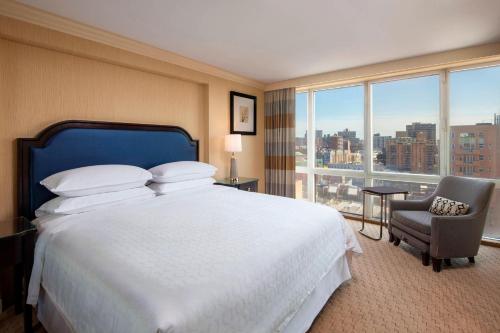 Sheraton LaGuardia East Hotel في كوينز: غرفة فندقية بسرير كبير ونافذة