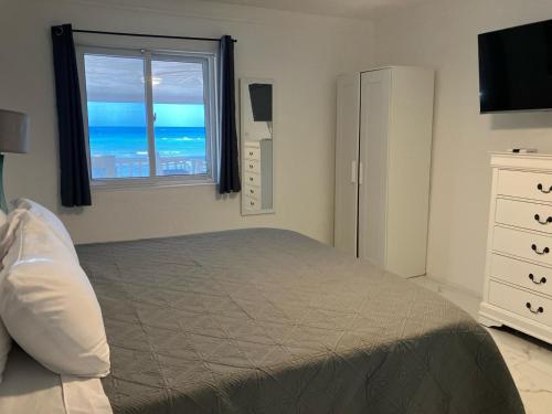 a bedroom with a bed and a window with the ocean at Stay BnB in Nassau