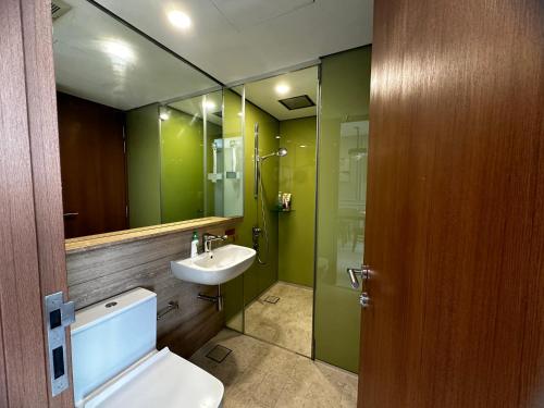 Un baño con inodoro, lavabo y espejo. en High Floor Lux Apartment Across KLCC, en Kuala Lumpur