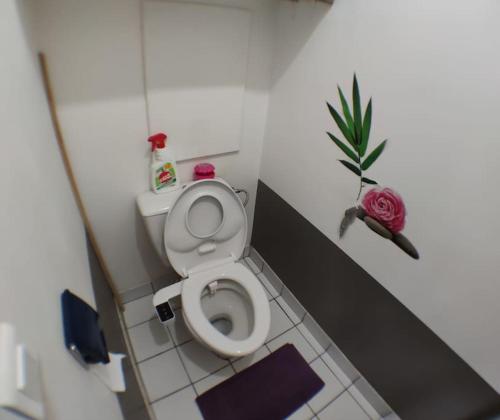 ein kleines Bad mit einem WC und einer Blume in der Unterkunft Cosy appart T4 90m~ Proche Paris - 5 min du RER C in Arpajon