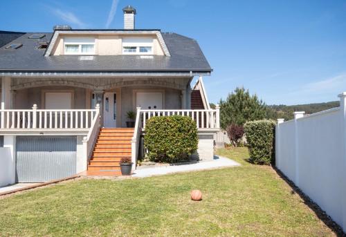 a house with a white fence in front of a yard at AG Casa Nosa Playa Pedra do Sal a 500 metros in Lema