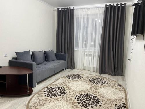 ein Wohnzimmer mit einem Sofa und einem Tisch in der Unterkunft 2х комнатная квартира с кодовым замком in Oral