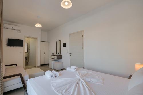 a white bedroom with a bed and a living room at Fabeno Villa in Sarandë