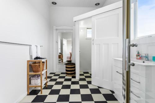 een badkamer met een zwart-wit geruite vloer bij Spacious Kingsland 4BR Home in Auckland