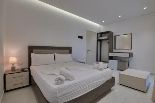 a bedroom with a large bed with white sheets at Fabeno Villa in Sarandë