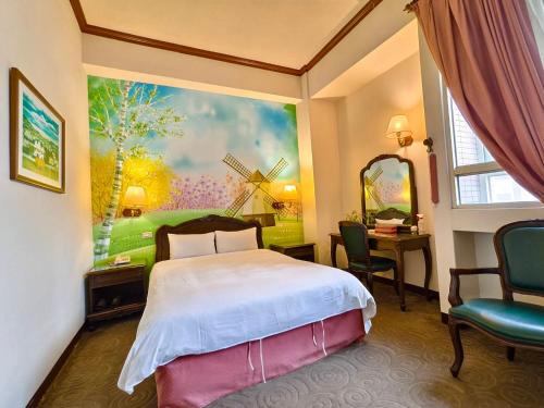 une chambre avec un lit et une peinture d'un moulin à vent dans l'établissement East Commercial Affairs Hotel, à Luodong