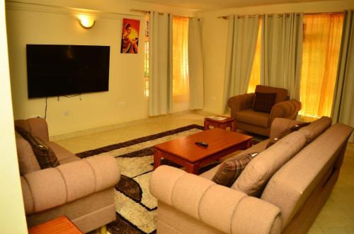 een woonkamer met 2 banken en een flatscreen-tv bij Musundi Luxury Homes in Kakamega