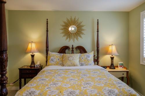 a bedroom with a bed and two lamps and a mirror at Old Town Country Landing in Niagara on the Lake