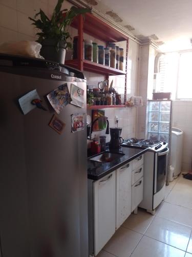 a kitchen with a stainless steel refrigerator and a sink at Quarto Aconchegante in Campos dos Goytacazes