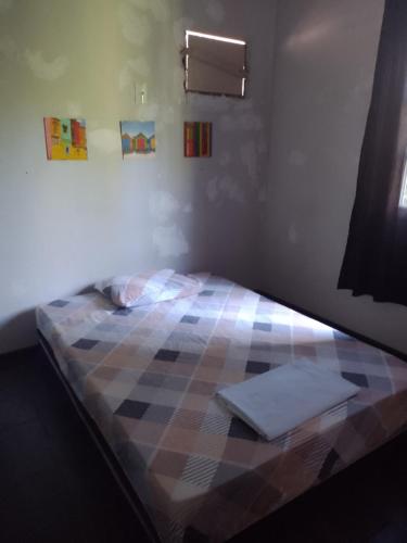 a bedroom with a bed with a checkeredkered at Quarto Aconchegante in Campos dos Goytacazes