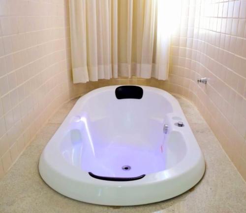 El baño incluye una bañera con una cara dibujada en ella. en HOT SPRINGS HOTEL Caldas Novas-FLAT VIP en Caldas Novas