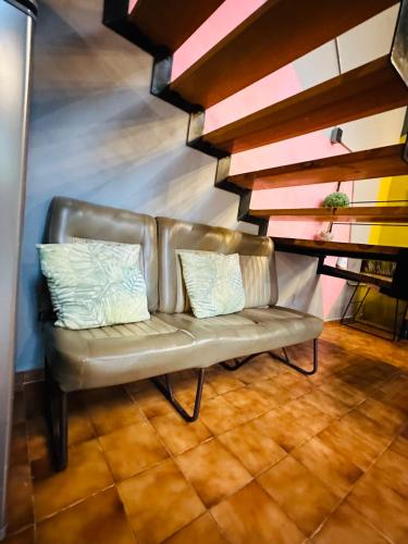 a leather couch with two pillows on it in a room at Loft Industrial Morelia in Morelia