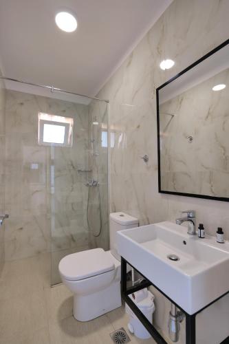 a bathroom with a toilet and a sink and a shower at Fabeno Villa in Sarandë