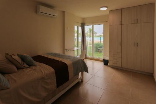 a bedroom with a bed and a large window at Departamento Laguna Turquesa in Veracruz