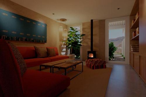a living room with a red couch and a table at Acogedora Casa en Condominio Oasis in Paracas