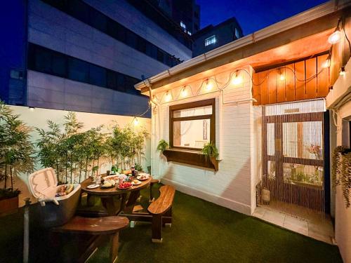 un patio con mesa y sillas en un edificio en Yunseul- Garden House in the City with Korean Beauty, en Seúl
