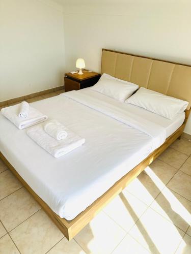 a bed with white sheets and towels on it at Portimao Central Holiday Guesthouse in Portimão