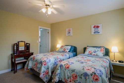 a bedroom with two beds and a ceiling fan at Old Town Country Landing in Niagara on the Lake