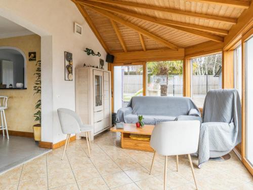 un salon avec un canapé et des chaises dans l'établissement Charmant gîte familial à La Baule avec jardin, terrasse, WiFi et équipements bébé - FR-1-306-1073, à La Baule