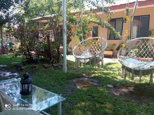 duas cadeiras e uma mesa de vidro num quintal em Hostal Familiar 2.0 em Chillán