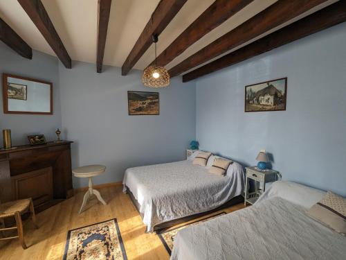 a bedroom with two beds and a table in it at Gîte champêtre avec jardin clos, près du lac d'Eguzon et Gargilesse-Dampierre ! - FR-1-591-127 in Orsennes