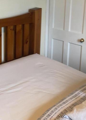 a white bed with a wooden frame and a white door at Renton Residence in Renton