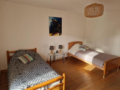 Un dormitorio con 2 camas y una mesa con lámparas. en Gîte Lunéville, 4 pièces, 5 personnes - FR-1-584-106, en Lunéville