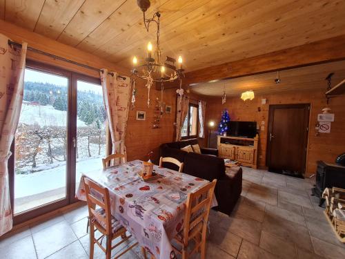 une salle à manger et un salon avec une table et des chaises dans l'établissement Chalet chaleureux face aux pistes, proche Gérardmer, idéal pour famille, balcon et terrasse - FR-1-589-182, à Ban-sur-Meurthe-Clefcy