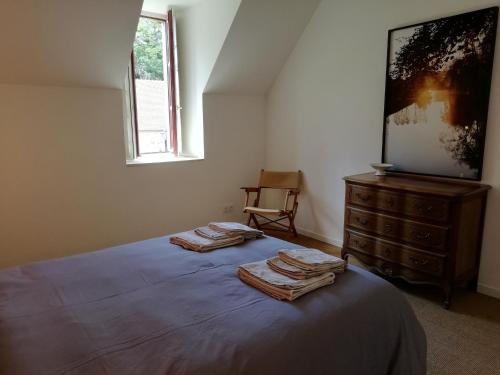 a bedroom with a bed with two towels on it at Gîte familial au calme avec parc et jardin, pour 8 personnes, près d’un château historique - FR-1-586-15 in Ainay-le-Vieil