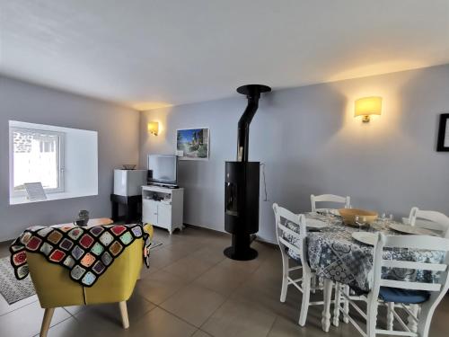 une salle à manger avec une table, des chaises et un poêle dans l'établissement Gîte rénové idéal pour randos et astronomie, calme assuré, proche Puy-en-Velay et activités nature. - FR-1-582-318, à Le Vernet