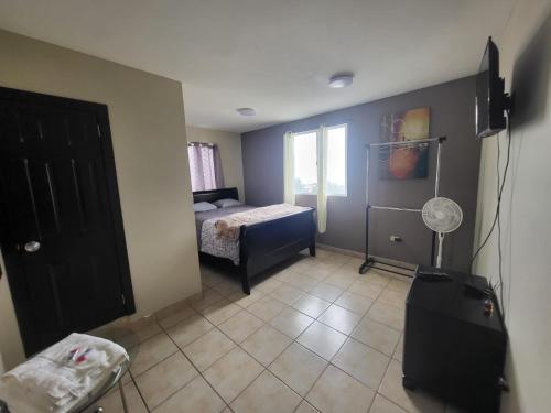 um quarto com um quarto com uma cama e uma janela em Departamentos velasco em Tijuana