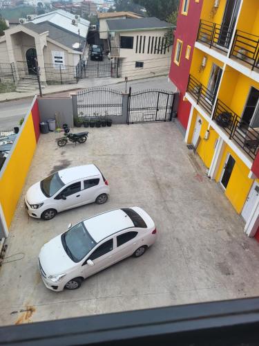 two cars parked in a parking lot next to a building at Departamentos velasco in Tijuana